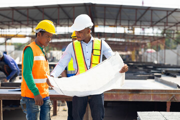 Professional Engineer Team working. Young architect Engineering and asian worker in safety hardhat and  looking at blueprint at industrial Heavy Manufacturing Factory. Prefabricated concrete walls