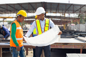 Professional Engineer Team working. Young architect Engineering and asian worker in safety hardhat and  looking at blueprint at industrial Heavy Manufacturing Factory. Prefabricated concrete walls