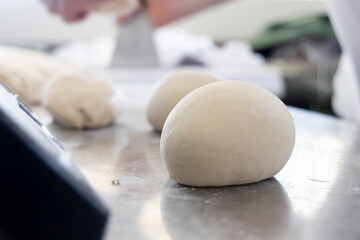 Fototapeta na wymiar The hands of a Neapolitan pizza chef working the dough