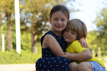 Fototapeta na wymiar Brother and sister are preschoolers. Lovely children 4-5 years old. The older sister takes care of the younger one. Best friends. Children on a walk. First love, care, hugs