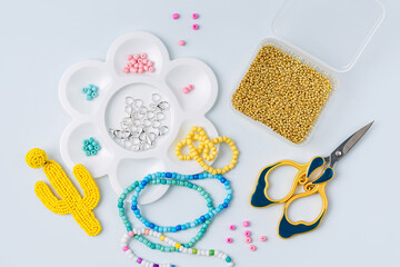 Set of for needlework and beading. Kids handmade beaded jewelry and different multi-colored beads for children's crafts in boxes. DIY art activity for kids. Motor skills, creativity and  hobby.