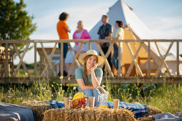 At the campsite very country style good looking pretty lady posing in front of the camera while other her friends chilling on the background