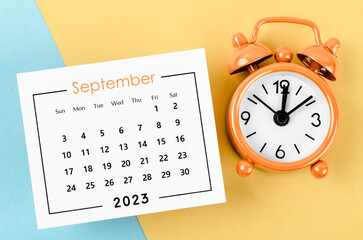 Fototapeta na wymiar The September 2023 Monthly calendar for 2023 year with alarm clock on beautiful background.