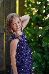 Fototapeta premium Portrait of a cute rural girl in a polka dot dress.