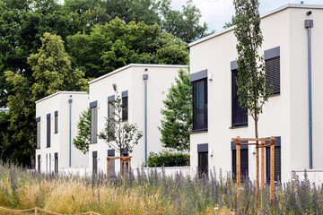Modern Facade Building Exterior with Landscaping. New Residential Multifamily Apartment Buildings with Minimalist Design in Germany with Perennial Garden.