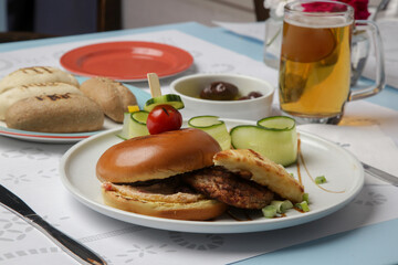 Fine casual dining: classic burger with cucumber slices served on the restaurant table