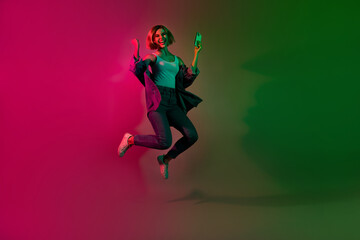Full length photo of crazy excited lady jumping winning web lottery eshopping isolated on colorful vivid neon background