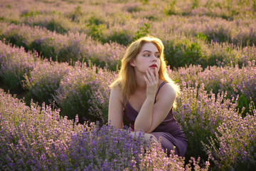 beautiful blonde girl with long hair on a lavender field in the evening - 625567625