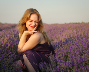 beautiful blonde girl with long hair on a lavender field in the evening - 625567674
