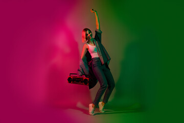 Full length photo of positive lady with audio boom box listen sound song dancing isolated on multicolor neon color background