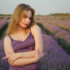 beautiful blonde girl with long hair on a lavender field in the evening - 625568681
