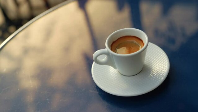 White espresso cup standing on a blue restaurant table