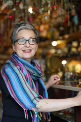 Portrait of a happy mature woman in an antique shop.