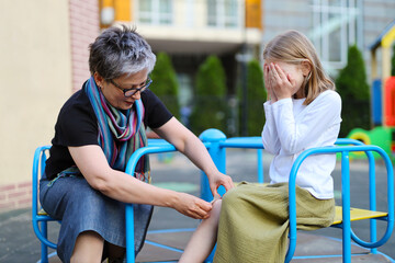 Obraz premium First aid for abrasions or scratches in a child on the playground.