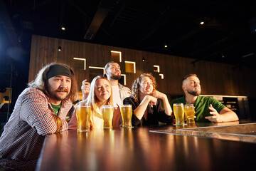 Group of friends meeting at pub, watching online football match translation, drinking beer, cheering up favourite team. Concept of sport competition, hobby, lifestyle, human emotions, fun
