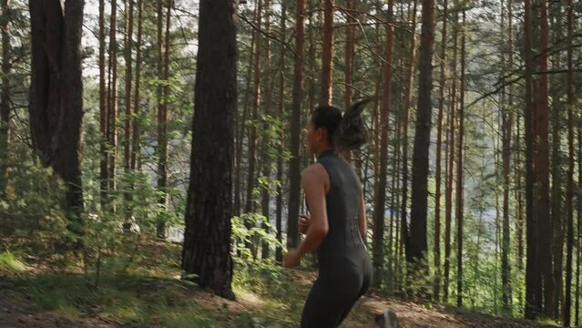 Young female athlete jogging in forest