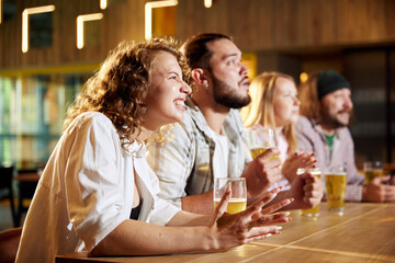 Sport fans, friends sitting at pub, bar, watching online football match translation, drinking beer, cheering up team. Concept of sport competition, hobby, lifestyle, human emotions, fun