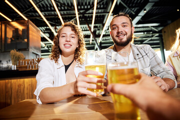 Friends meeting at bar, pub,watching football match translation, talking, cheering up favorite team. Clinking beer glasses. Concept of sport competition, hobby, lifestyle, human emotions, fun