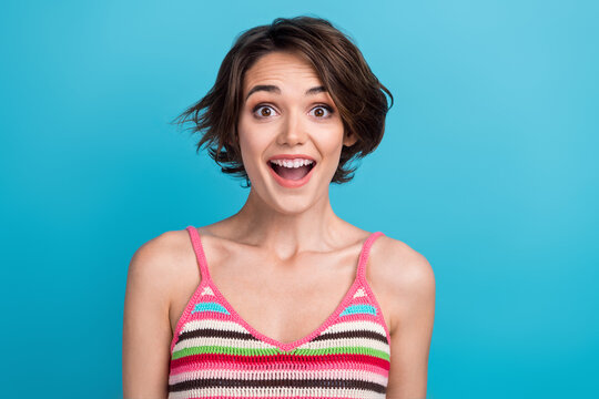 Portrait picture of funny youth woman bob brown hair wearing striped stylish singlet open mouth surprised isolated on blue color background