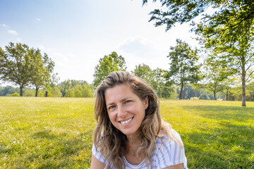 Fototapeta na wymiar Portrait of a beautiful smiling woman in the park. 
