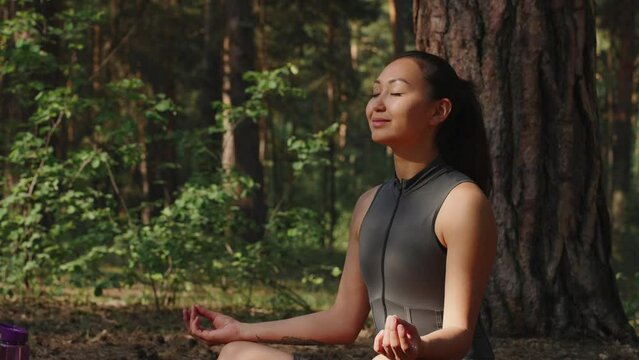 Young woman in sportswear meditating while practicing yoga