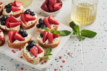 American flag sandwich with strawberries, blueberries, whipped sweet cream, soft cheese on toast bread. 4th of July American Independence Day food. Independence or Patriotic Day breakfast idea Mock up