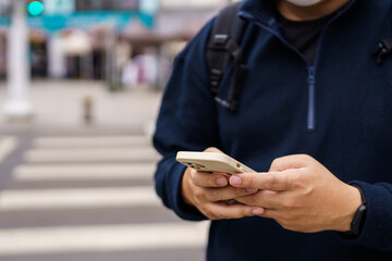 Man in downtown city street ordering taxi using smart phone app Booking taxi using application online on smart phone