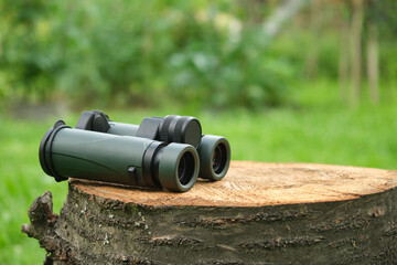 military binoculars green in nature on a tree stump