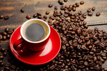 Black coffee or hot tea in a red coffee cup cappuccino espresso Breakfast with coffee beans on wooden table Isolated on black background. Top view.