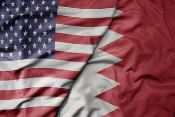 big waving colorful flag of united states of america and national flag of bahrain .