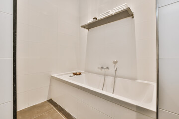 a bathroom with white tiles and black trim around the tub, sink, and faucet in it's corner