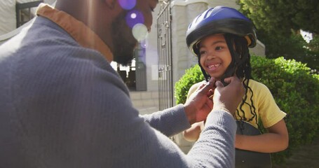 Happy african american father giving high five to daughter holding skateboard - Powered by Adobe