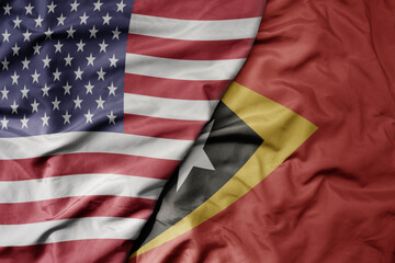 Obraz premium big waving colorful flag of united states of america and national flag of east timor .