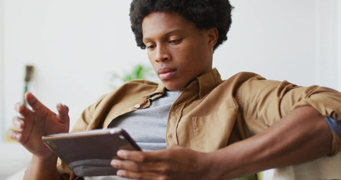 Happy african american man using tablet at home