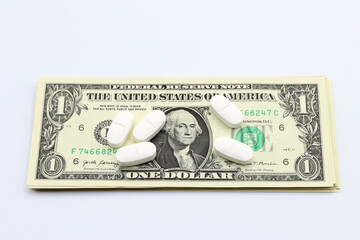 Pills or medications on a dollar bill.