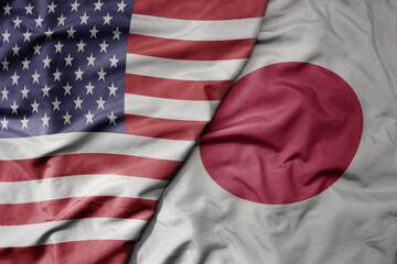 Obraz premium big waving colorful flag of united states of america and national flag of japan .