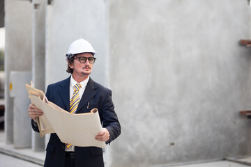 Caucasian construction architect Engineering  busines man in safety hardhat working on blue print at precast factory industrial. Heavy Industry Manufacturing Factory. Prefabricated concrete walls