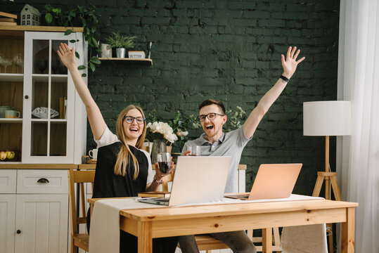 Two happy successful excited traders investors celebrating success stock exchange trading deal, rising crypto bull market shares, growth bitcoin stock, ipo profit victory concept. Works on a laptop.
