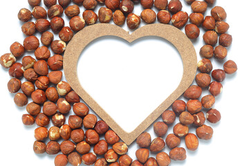 Heart shape made of nuts. Brown hazelnut kernels on a white background