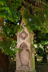 schöne alte Grabsäule unter einem Baum auf einem alten Friedhof in Roermond