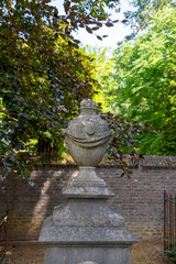 Steinerne Urne mit Schal auf einem alten Friedhof in Roermond