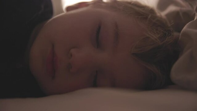 Face of little boy sleeping in bed and breathing