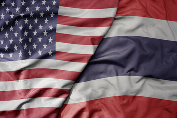 big waving colorful flag of united states of america and national flag of thailand .