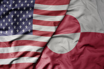 big waving colorful flag of united states of america and national flag of greenland