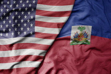 big waving colorful flag of united states of america and national flag of haiti .