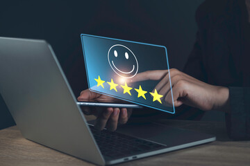Customer Experience feedback concept. Businessman give five stars with smiley face for the best excellent evaluation of satisfaction; service like; Good quality; High rating; very good by laptop.