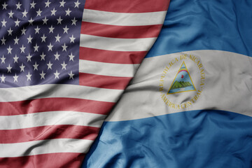 big waving colorful flag of united states of america and national flag of nicaragua .