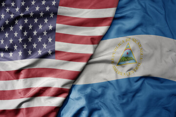 Obraz premium big waving colorful flag of united states of america and national flag of nicaragua .