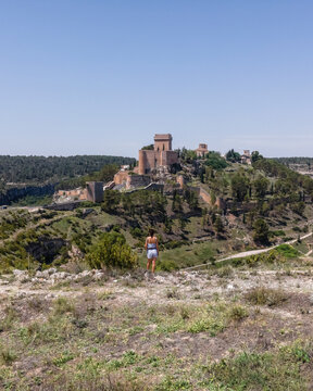Aerial view of a woman in Alarcon, a medieval town with castle on top along the Rio Jucar river in Cuenca, Spain.