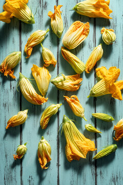 Zucchini flowers on delicate pastel wooden background.